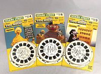 Three unopened vintage View-Master packages from Sesame Street featuring Alphabet, Baby Animals, and Counting themes, showing front packaging and reels.