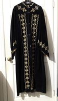 Front view of black velvet robe with gold embroidery, showing snap front closure and intricate designs on chest and cuffs.
