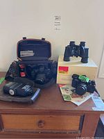 Lot contents showing Canon EOS Rebel G camera in padded case, Vivitar flash unit, 35mm film canister and additional accessories.