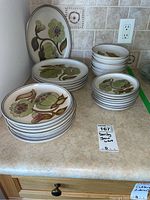 Full set arranged on counter showing all plate sizes and bowls stacked.