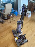 Overview of Dyson Ball Animal 2 vacuum standing upright with all attachments laid out