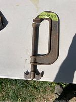 Taylor Forbes Co. metal C-clamp lying flat showing front face and screw mechanism.