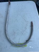 Full view of the large curved fishing hook showing size and overall condition.