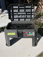 Rubbermaid Roughneck stepstool toolbox with lid open showing tool tray inside and latch on front