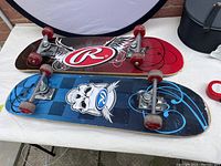 Two Rawlings skateboards displayed side by side on white surface, showing the top deck artwork and trucks/wheels.