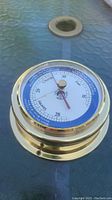 Full view of the brass Chelsea maritime barometer showing the face dial with weather pressure readings and polished brass casing.