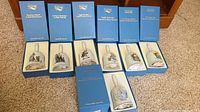 Lot of 7 vintage Hummel Christmas bells by Schmid with original blue collector series boxes. Bells decorated with images based on Berta Hummel's artwork.