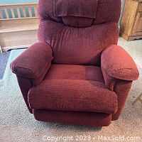 Front view of burgundy La-Z-Boy recliner chair showing cushioned seat, armrests, and backrest upholstery.