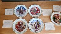 Five Lenox International Victorian Santa Series plates laid out on a wooden surface, each with a decorative green leaf patterned rim and colorful cultural Santa illustrations central.