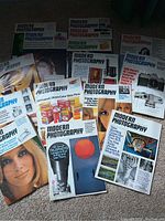 Photo showing a group of 14 Modern Photography magazines spread out, featuring portraits and camera equipment on the covers from 1966-1970.