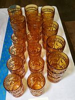 Top-down view of the 24 amber glasses arranged in rows on a table