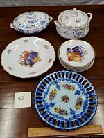 Full view of all items including two pottery serving pots, multiple plates, and lattice plate showing detailed items in the lot