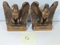 Pair of brass American eagle bookends showing front view with 1776 date imprint on base and detailed eagle designs