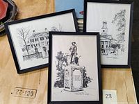 Three framed black and white pen and ink drawings arranged on a wooden surface depicting Boston area landmarks by R. E. Kennedy