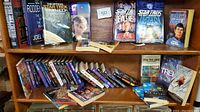 Wide view of Star Trek and SciFi books on shelves showing a mix of paperbacks and hardcovers, some visibly signed.