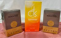 Front view of three unopened fragrance boxes: one Calvin Klein One Summer 2010 100ml and two Azzaro Wanted 50ml bottles.