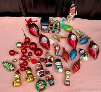 Wide view of the complete lot showing the variety of vintage glass Christmas ornaments including figural, tree, bird, and bauble shapes.