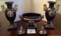 Full set of two urns flanking oval bowl on tabletop