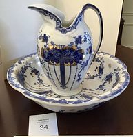 Pitcher and bowl together showing the overall set with blue, white, and gold decoration.