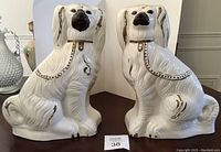 Front view of both cream ceramic Wally dogs on display