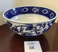 Side view of the blue and white pottery bowl showing the floral design on the exterior.