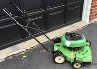 Side view of the green Lawn Boy push mower showing condition and handle design