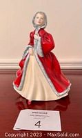 Full front view of Royal Doulton Rachel figurine showing red cape and pale yellow dress with fur trim detail.