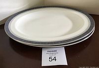 Two Royal Doulton Sherbrooke pattern oval serving platters stacked on each other showing top platter fully and the bottom one partially visible