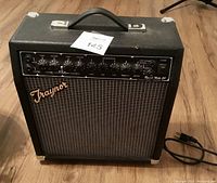 Front angled view showing control panel and brand logo on grille cloth.