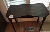 Top view of the kidney-shaped dark stained wooden table showing surface and curved shape.