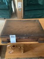 Closed wooden cutlery canteen with visible scratches and wear on top surface.