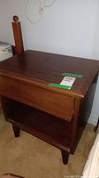 Side table showing general condition and design with a drawer and open shelf below.