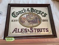 Front view of the framed bar mirror showing the painted image and text 'Coach & Horses' with horses and carriage, in wood frame.