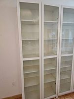 Front view of white Billy bookcase with two glass doors closed