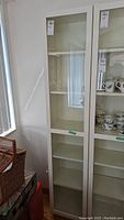 Front view of assembled white cabinet with glass door, labelled lot 780