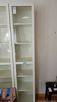 Front view of the Ikea Billy shelf cabinet with glass door closed, showing clear glass panels and cabinet structure.