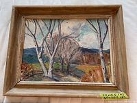 Full view of the framed oil painting showing the landscape scene with trees, river, and mountains.