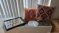 Wide photo showing all items including two throw pillows, the serving tray with photo holders, the wall clock, and the alarm clock on a glass surface in front of vertical blinds.