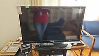 Front view of Samsung 32 inch LED TV on stand with remote placement visible.