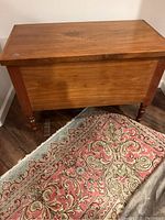 Full view of the closed cedar wood chest showing top, front, side and legs.