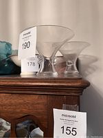 Two Steuben Thumbprint glass bowls with flared rims and thumbprint details visible from side angle on wood furniture.