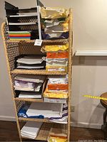 Photo showing wicker shelves holding multiple stacks of copy and colored paper.
