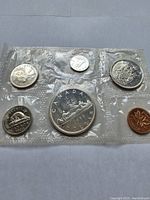 Canadian 1966 proof coins in sealed plastic, showing reverse sides with Canadian imagery including beaver, canoe, maple leaf, etc.