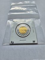 2014 Fine Silver Canadian Proof Toonie coin sealed in protective cardboard holder inside a plastic bag, showing polar bear and denomination sides.