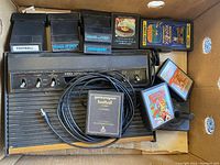 Photo showing Atari 2600 console, game cartridges including Football, Space Attack, Astrobelt, Frogs and Flies, and boxed cartridge Xonox