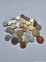 Top view of various coins arranged in a scattered pile showing different metals and designs.