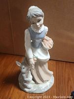 Front view of porcelain figurine showing girl with basket and rabbit