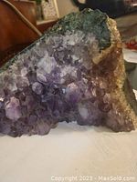 Front view of large amethyst crystal cluster showing the dark purple crystals and natural textures.