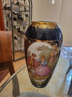 Full view of the Limoges vase showing the cobalt blue background, oval painted scene, and gold rim.
