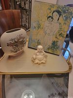 Lot showing the Satsuma-style vase, Buddha figurine, and signed mother/child artwork together on a tray